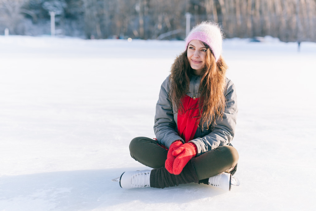 Patinaje sobre hielo mujer sentada en el hielo sonriendo
 - Foto, imagen