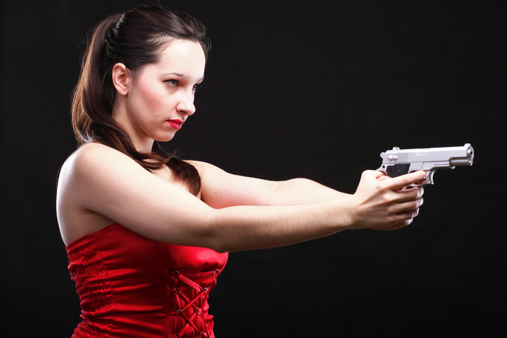 Szexi fiatal nő - gun fekete háttér - Fotó, kép