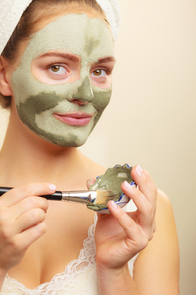 Εφαρμογή με πινέλο μάσκα λάσπη αργίλου στο πρόσωπο της γυναίκας  - Φωτογραφία, εικόνα