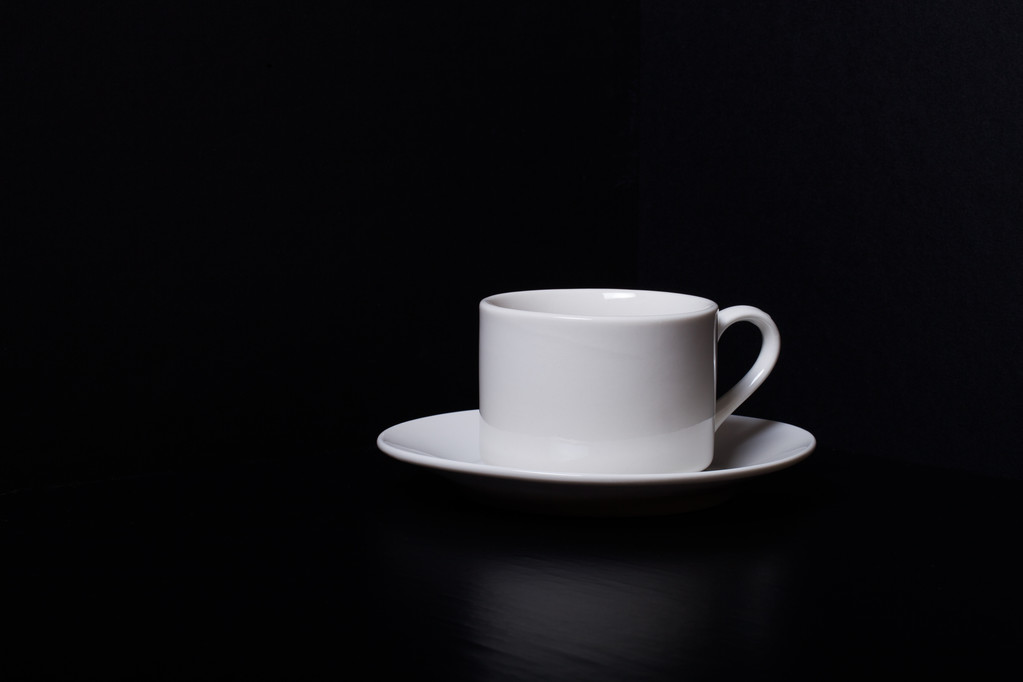 Csésze és csészealj egy fekete háttér - Fotó, kép