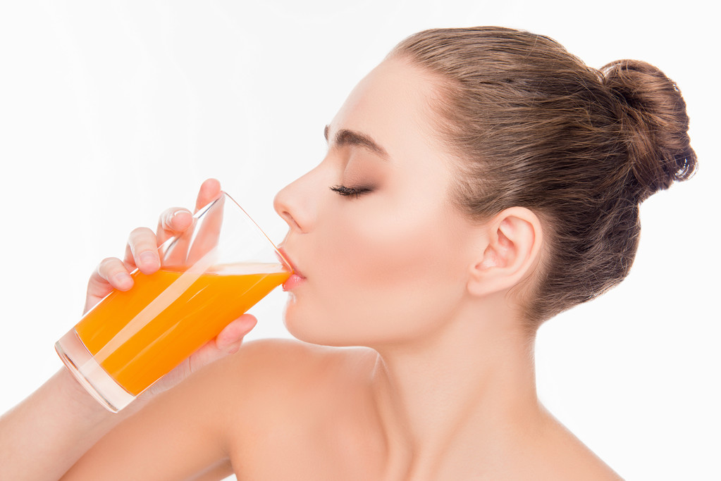 オレンジジュースを飲む美しい若い女の子、クローズアップ写真 - 写真・画像