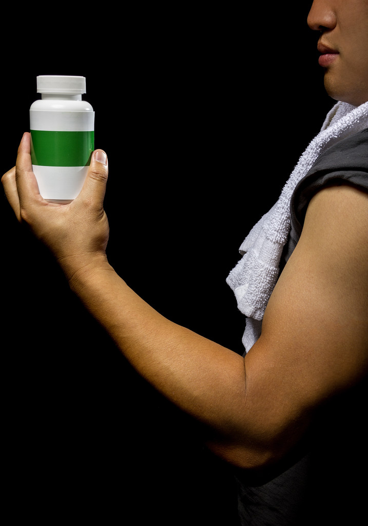 Male with bottle of energy booster supplement - Photo, Image