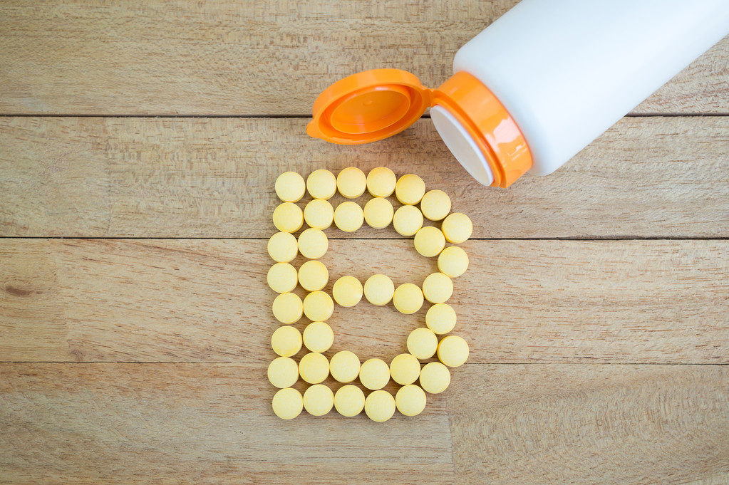 B Complex pills forming shape to B alphabet on wood background - Photo, Image