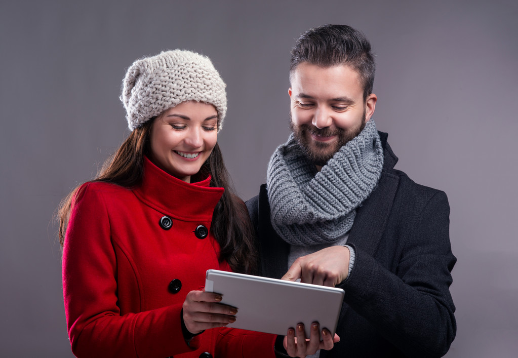 Jovem mulher e homem em casacos de inverno com tablet
 - Foto, Imagem