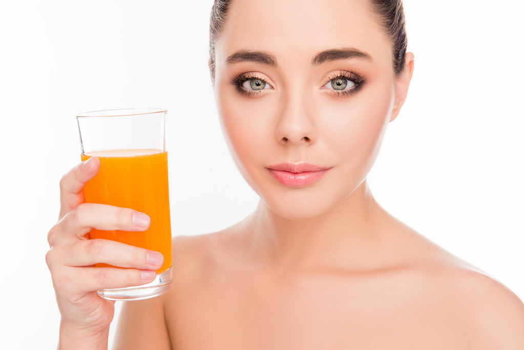 オレンジ ジュースのガラスを保持している笑顔の女性の写真をクローズ アップ - 写真・画像