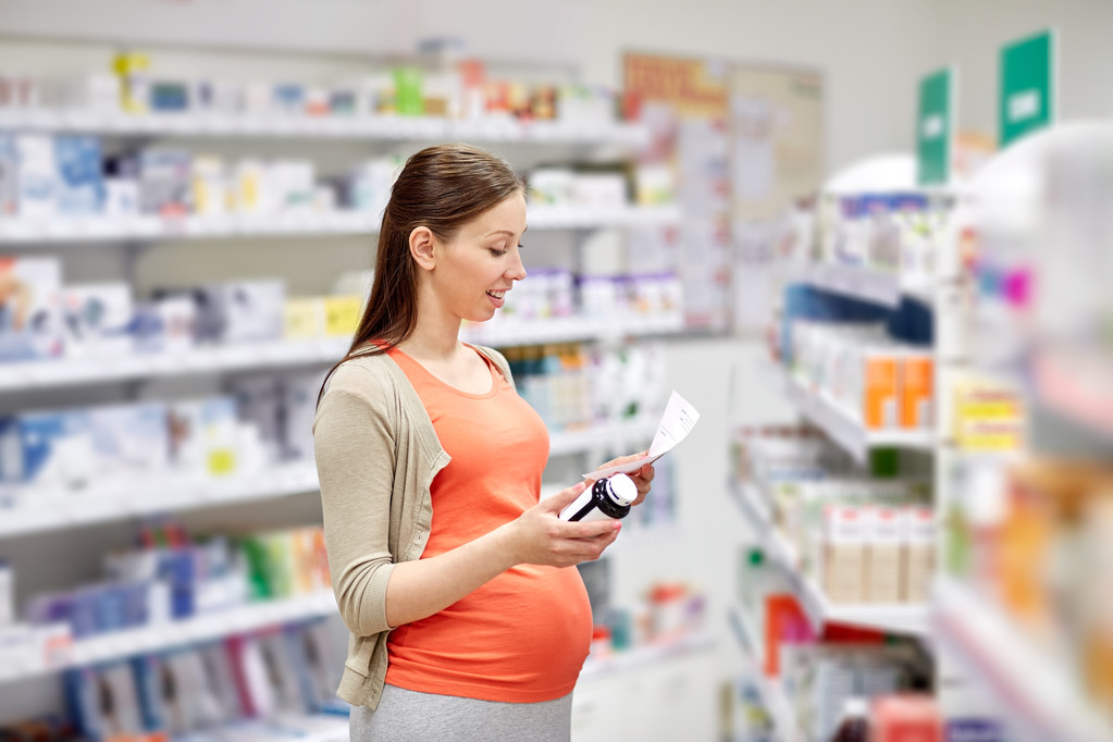 mulher grávida feliz com medicação na farmácia
 - Foto, Imagem