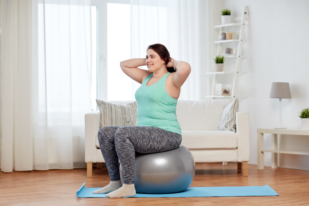 plus size vrouw trainen met fitness bal - Foto, afbeelding