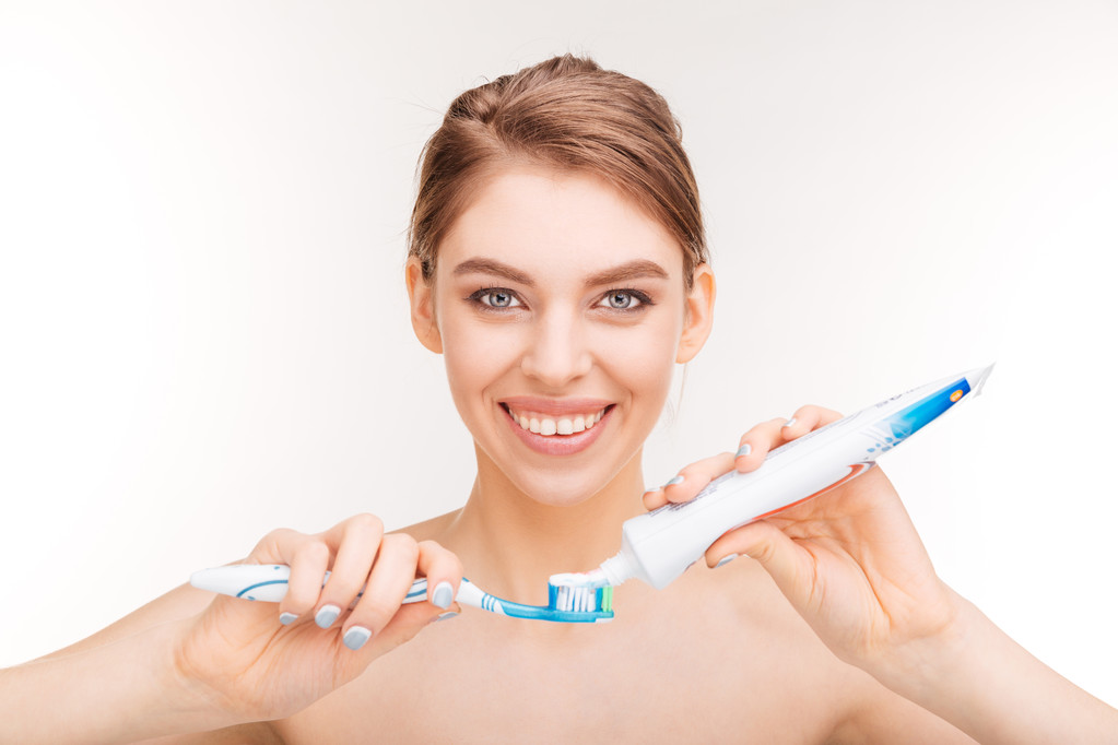 Piękno portret uśmiechniętej młodej kobiety za pomocą pasty do zębów i szczoteczki do zębów - Zdjęcie, obraz
