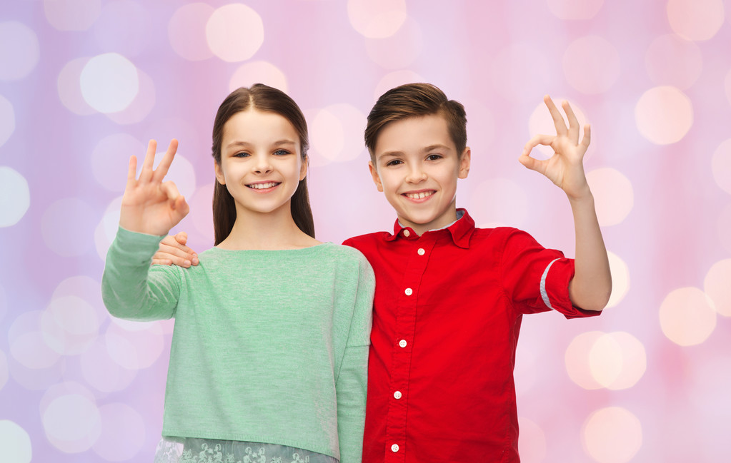 boldog fiú és lány ok kéz jel mutatja - Fotó, kép