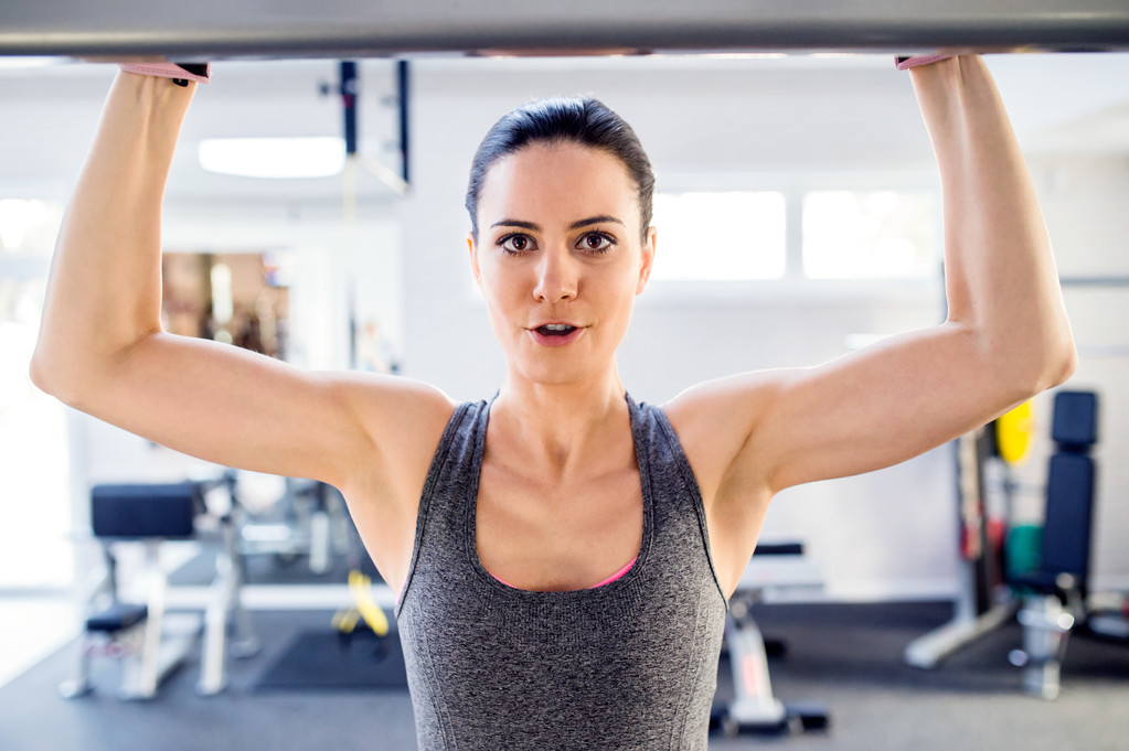 Woman in gym doing arms exercises - Photo, Image