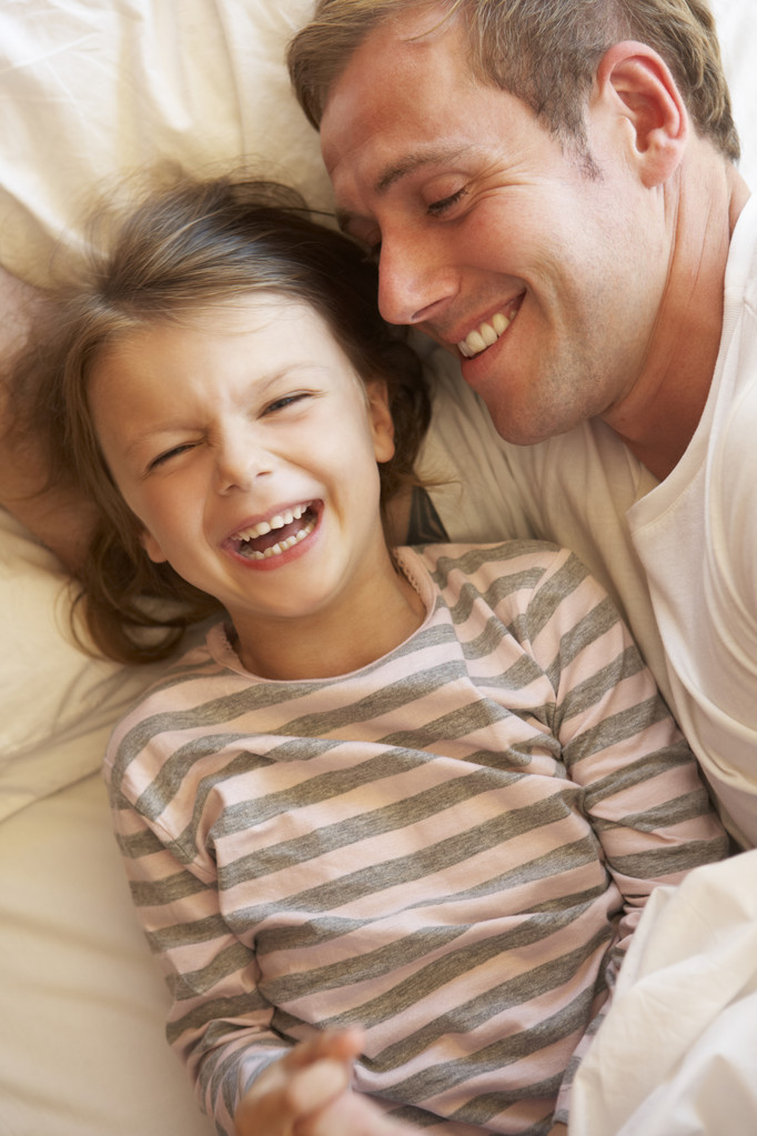 Père et fille se relaxant au lit
 - Photo, image