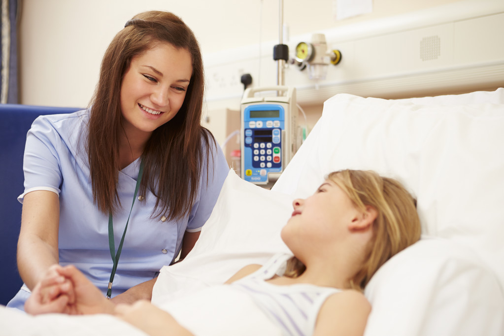 Медсестра сидить біля ліжка дівчини в лікарні
   - Фото, зображення