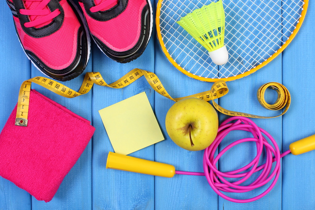 Růžové sportovní obuv, čerstvé jablko a doplňky pro sport na modré desky, kopie prostor pro text na listu papíru - Fotografie, Obrázek