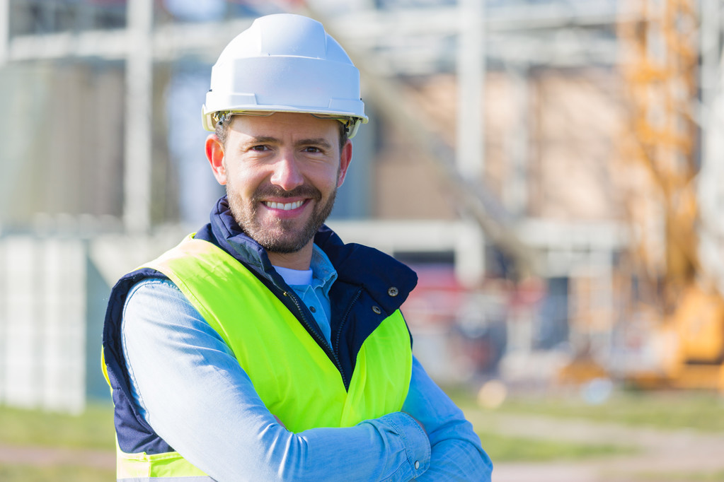 Portret van een aantrekkelijke werknemer op een bouwplaats  - Foto, afbeelding