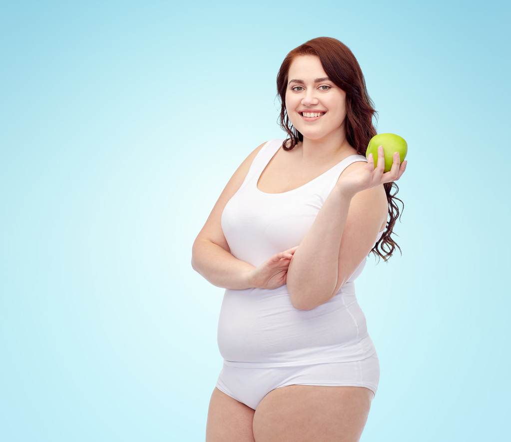 γυναίκα ευτυχισμένη συν μέγεθος εσώρουχα με μήλο - Φωτογραφία, εικόνα