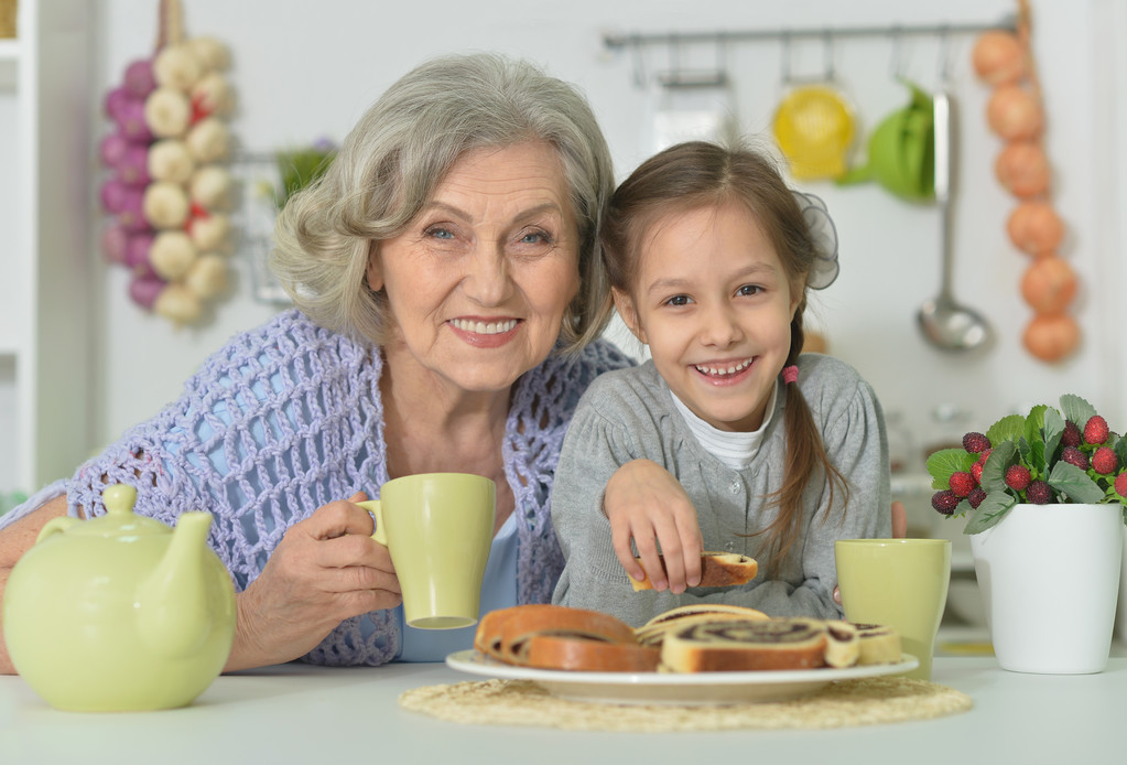 Старшая женщина с внучкой с чаем
 - Фото, изображение