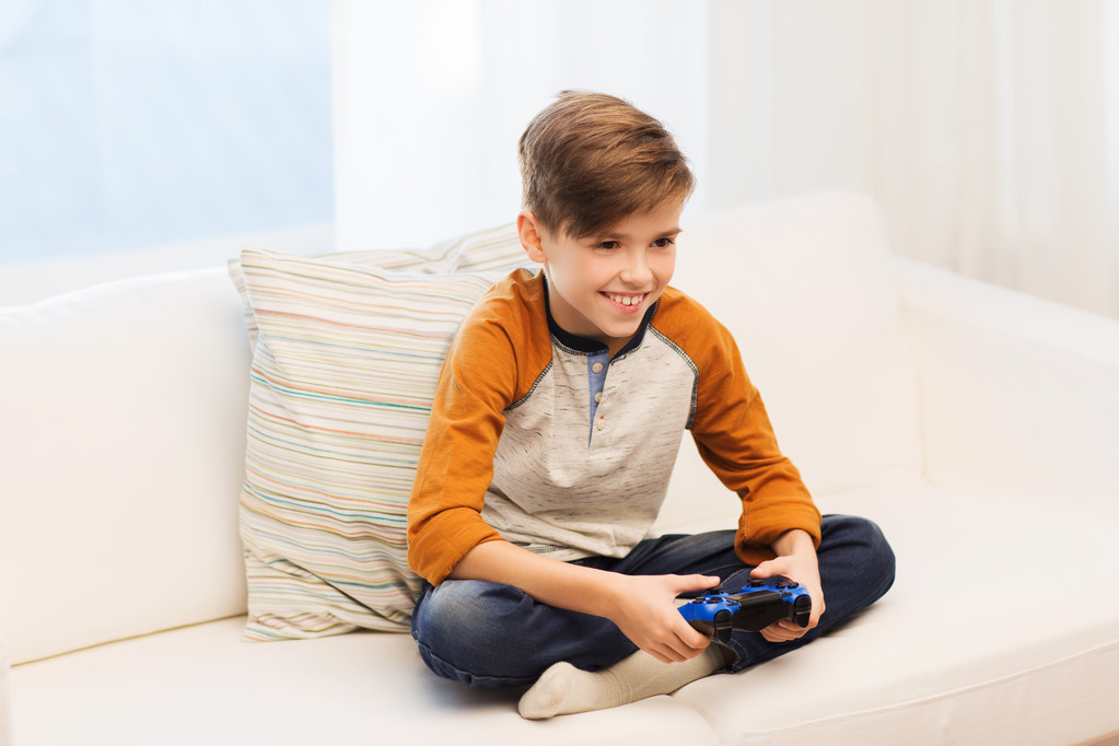 Ευτυχισμένο αγόρι με joystick αναπαραγωγή βίντεο παιχνίδι στο σπίτι - Φωτογραφία, εικόνα