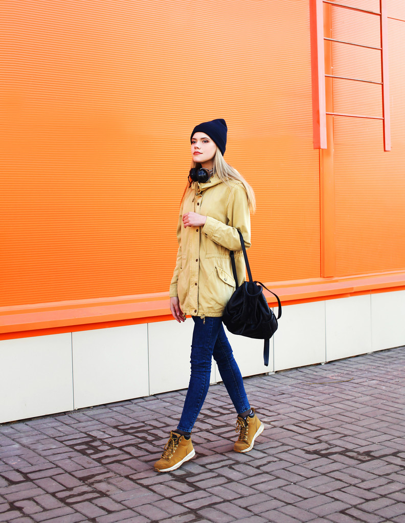 Мода красива дівчина, що йде містом на помаранчевому фоні
 - Фото, зображення