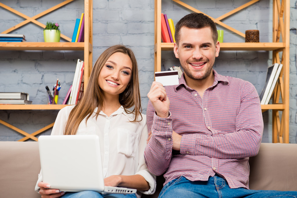 Mann und Frau kaufen mit Laptop und Bankkarte im Internet ein - Foto, Bild