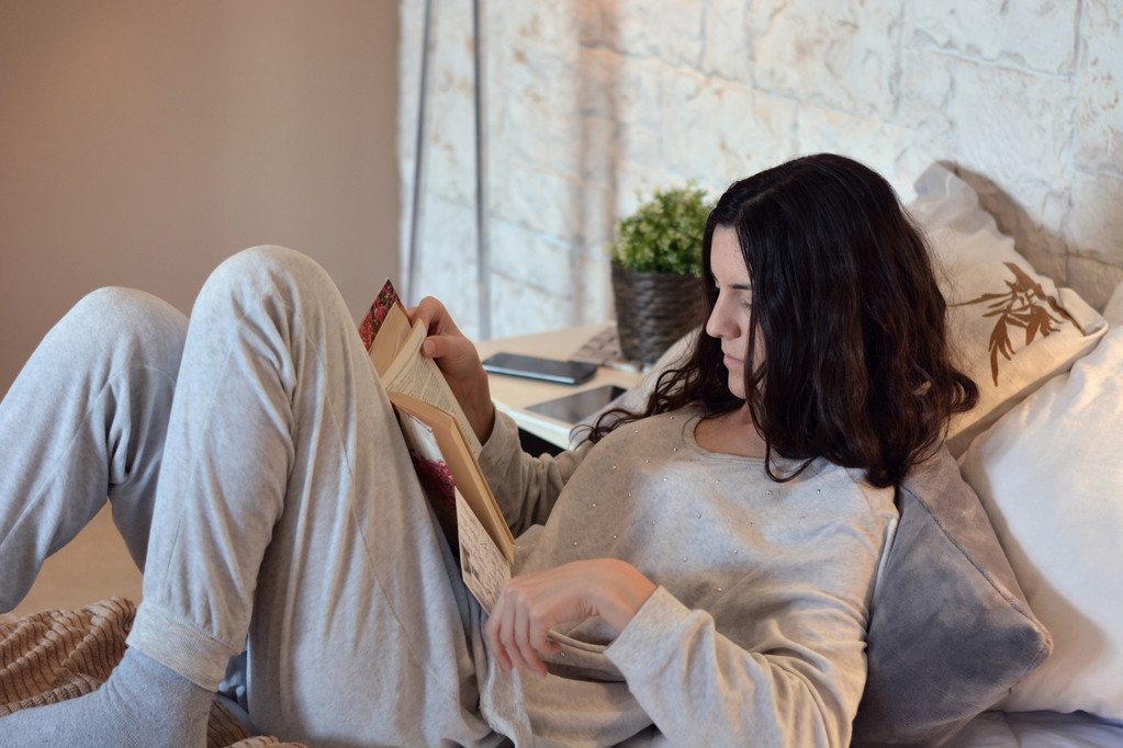 Mulher lendo um livro na cama
  - Foto, Imagem