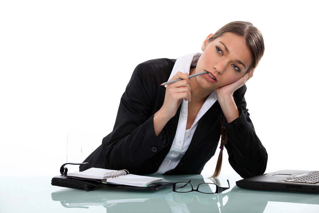 Pensive businesswoman sitting at a desk - Photo, Image