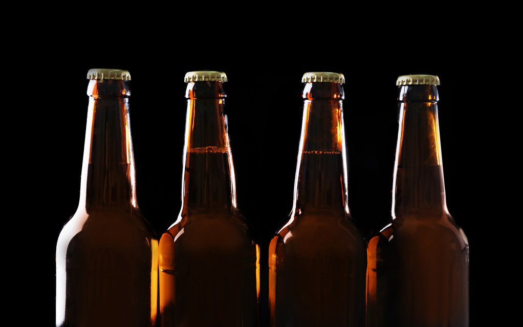Négy üveg sör-fekete háttér - Fotó, kép