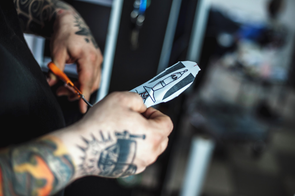 Tatuagem masculina artista mostra um esboço
 - Foto, Imagem