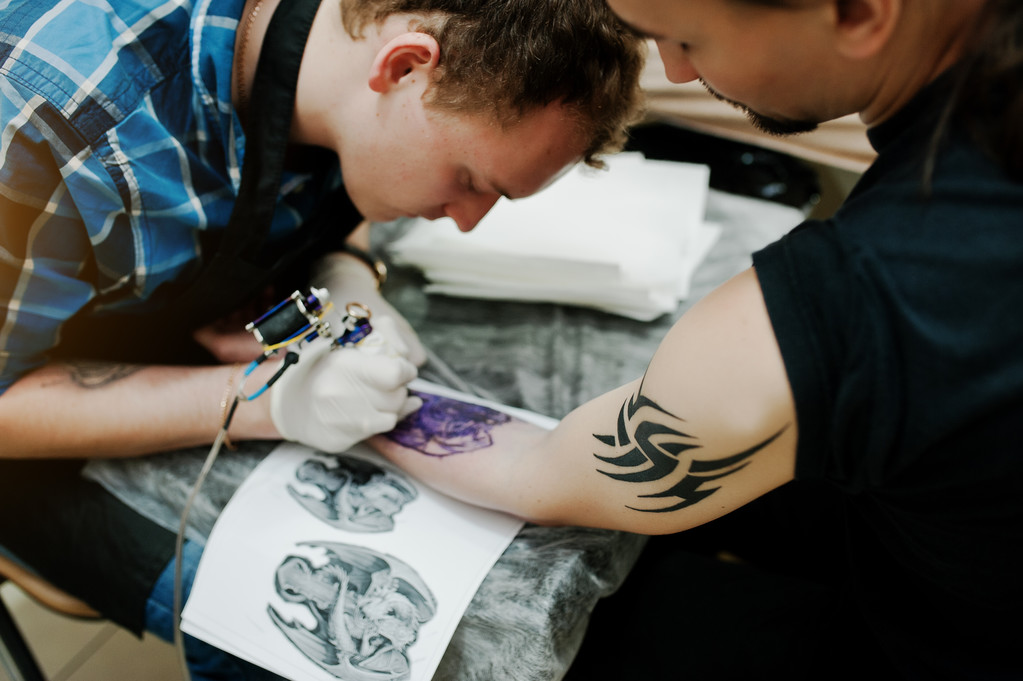 タトゥー サロンでロッカー男のタトゥーを作るタトゥー マスター - 写真・画像