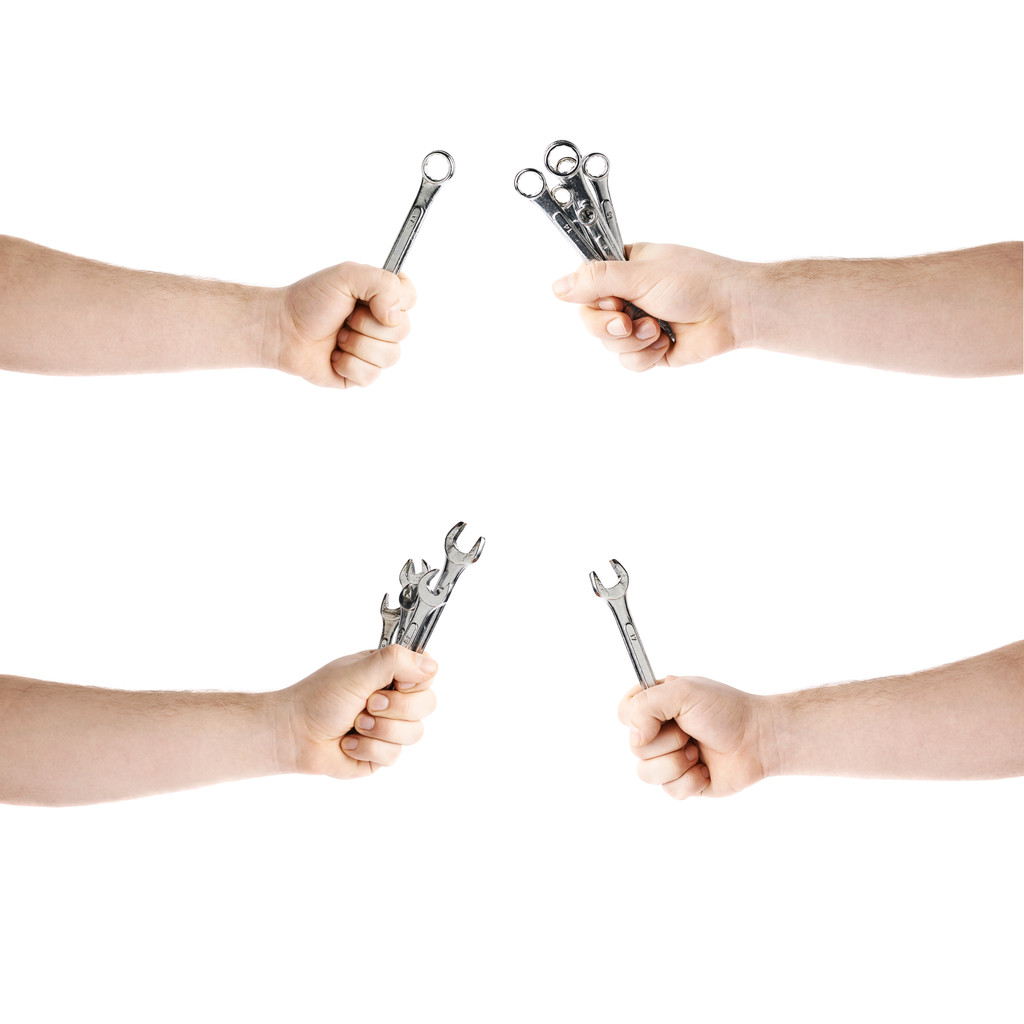 Σύνολο χέρι που κρατά ένα γαλλικό κλειδί εργαλεία, σύνθεση απομονωθεί πάνω από το λευκό φόντο - Φωτογραφία, εικόνα