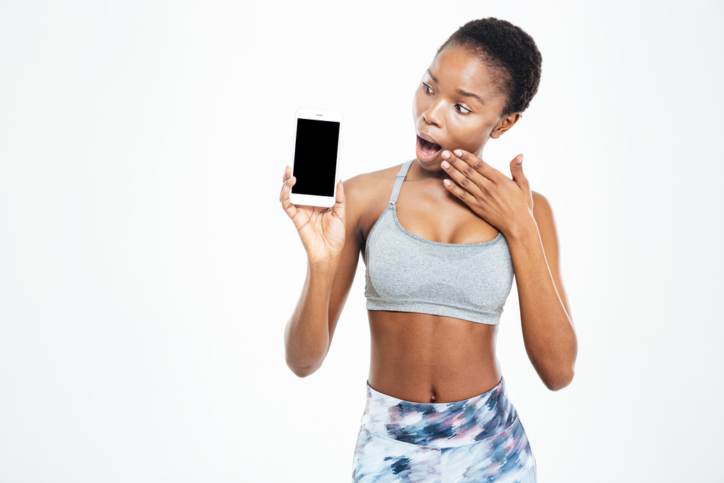erstaunt afrikanisch-amerikanische Sportlerin schaut auf leeren Bildschirm Handy  - Foto, Bild