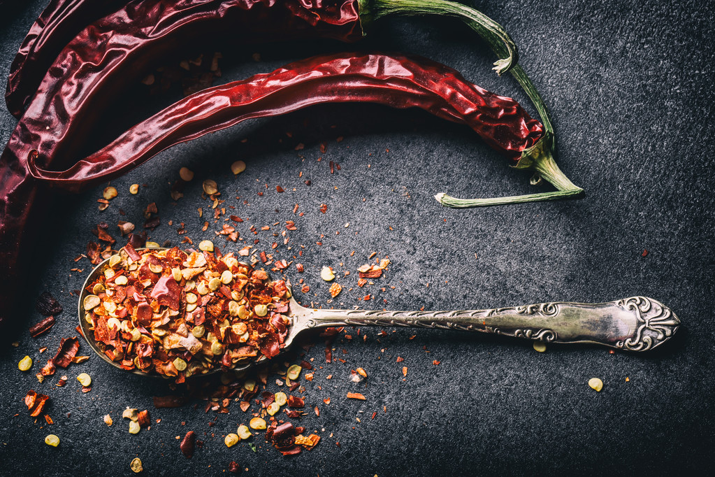 Chili. Chili peppers. Several dried chilli peppers and crushed peppers on an old spoon spilled around. Mexican ingredients - cuisine - Photo, Image