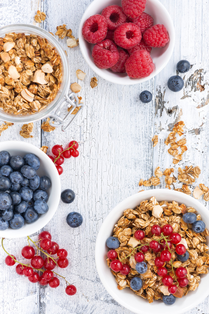 granola and fresh berries on white wooden background - Photo, Image
