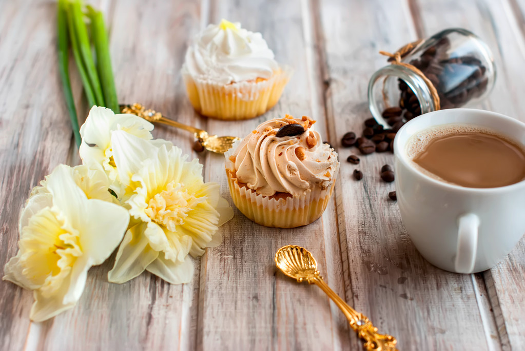 Bolo e café cupand um buquê de narcisos
 - Foto, Imagem