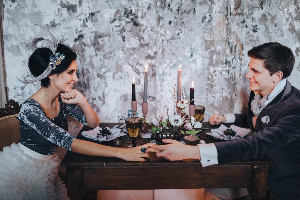 Noiva e noivo sentados à mesa servida
 - Foto, Imagem