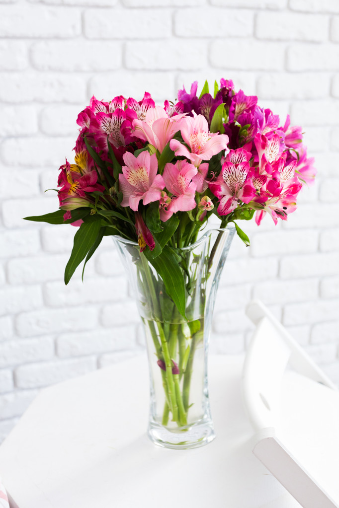 Ваза, повна різнокольорових квітів на столі
 - Фото, зображення