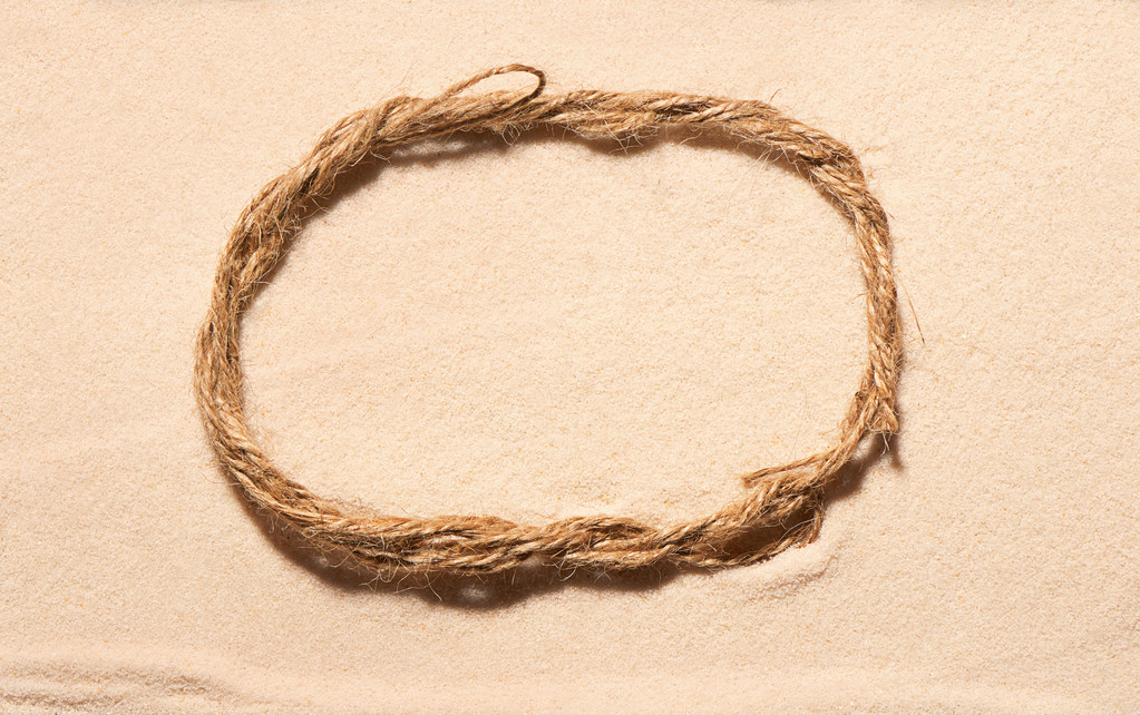 Marco oval de cuerda sobre arena
 - Foto, imagen