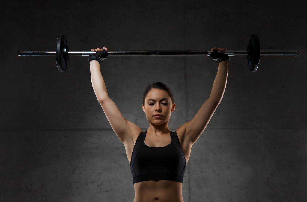 jeune femme flexion des muscles avec haltère dans la salle de gym
 - Photo, image