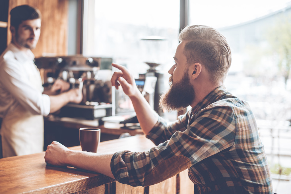  bebaarde man met koffie en barista - Foto, afbeelding