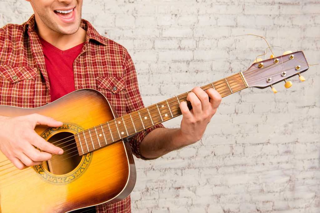 Primer retrato de un hombre alegre tocando la guitarra y el pecado
 - Foto, imagen