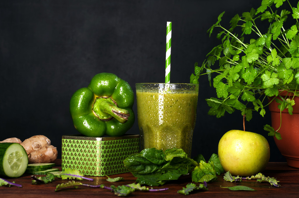A freshly prepared smoothie of apples, spinach, ginger and cucumber with a glass of glass on a black background. Near vegetables and herbs. The concept of a vegetarian diet. Low-calorie cocktail for rapid weight loss - Photo, Image