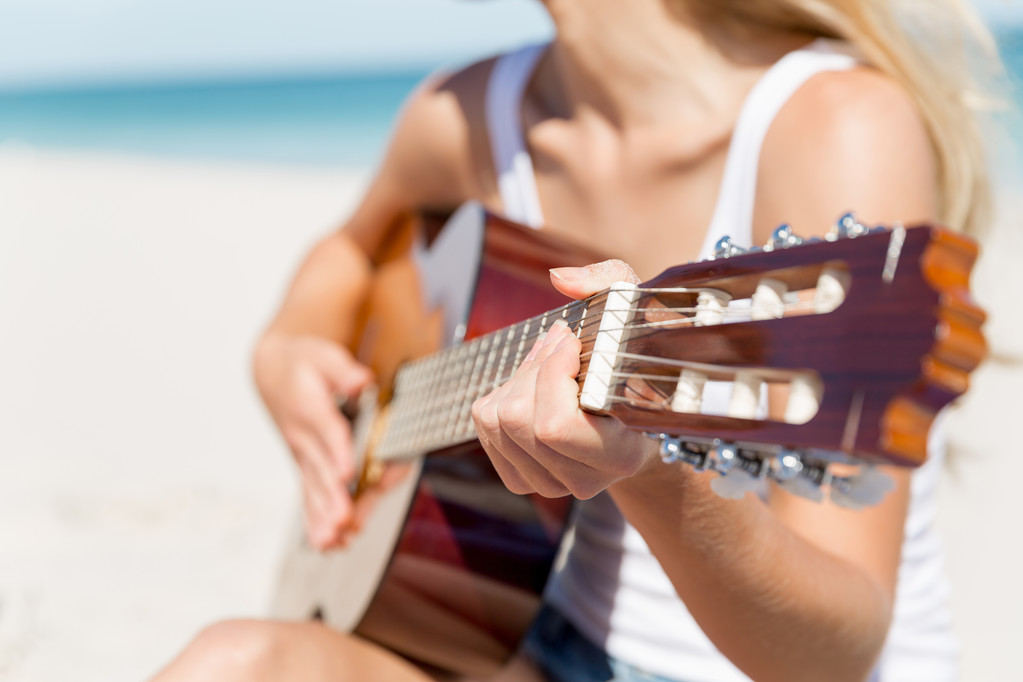красива молода жінка грає на гітарі на пляжі
 - Фото, зображення