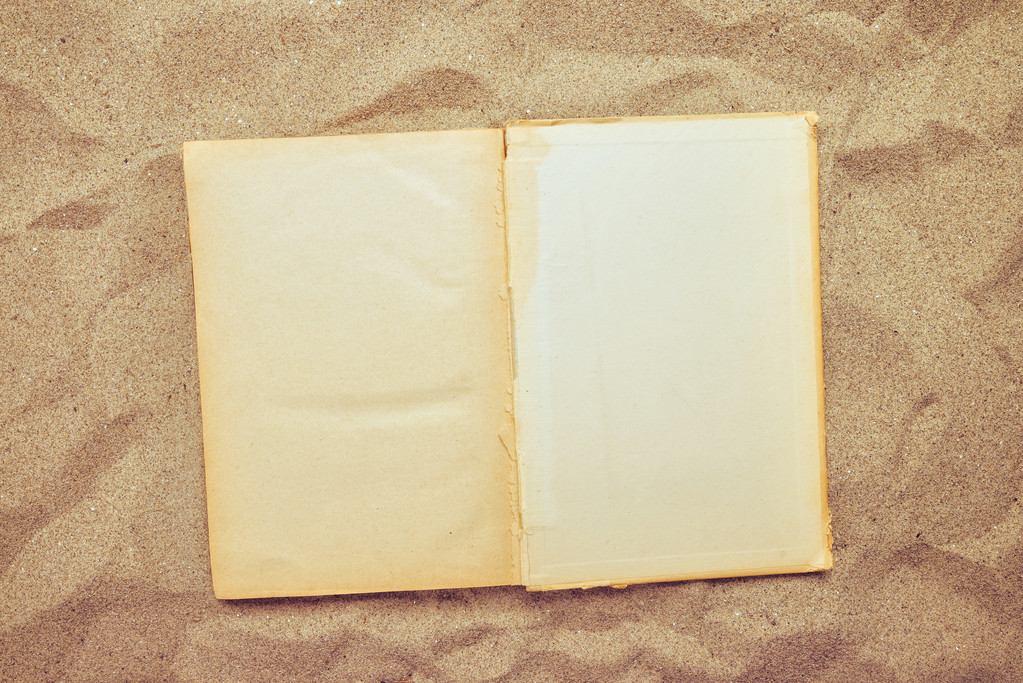 Vista superior do livro aberto vintage na praia arenosa
 - Foto, Imagem