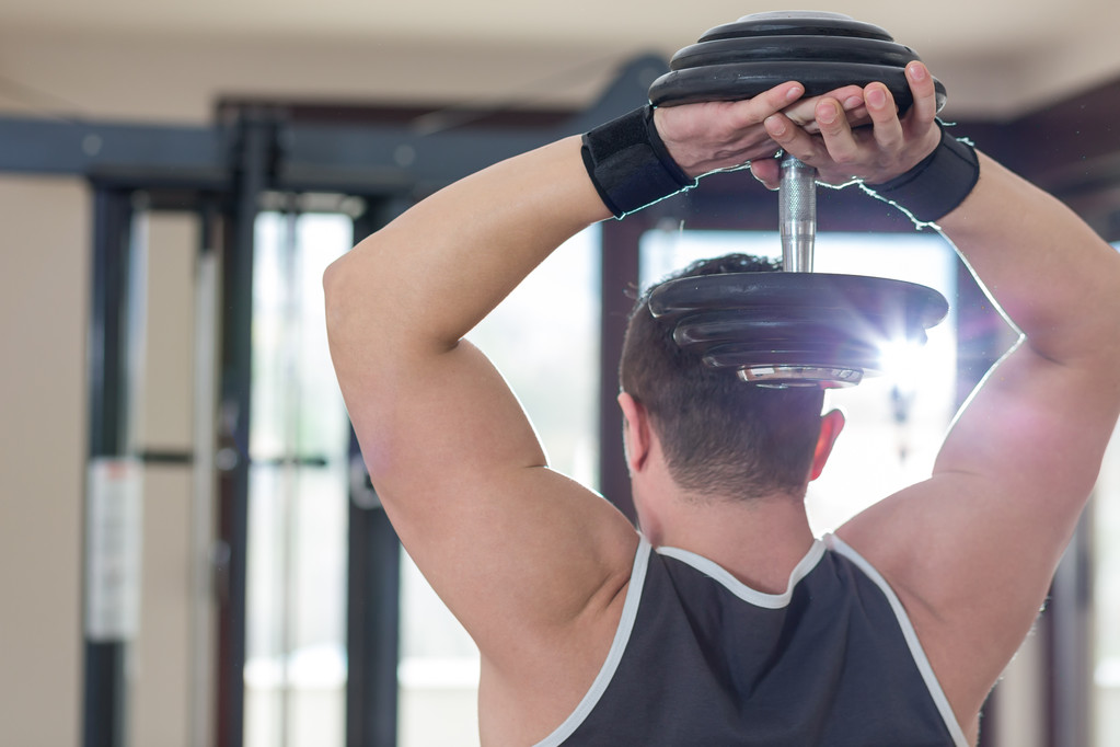 Спортсмен мускулистый культурист демонстрирует свои мышцы в
 - Фото, изображение