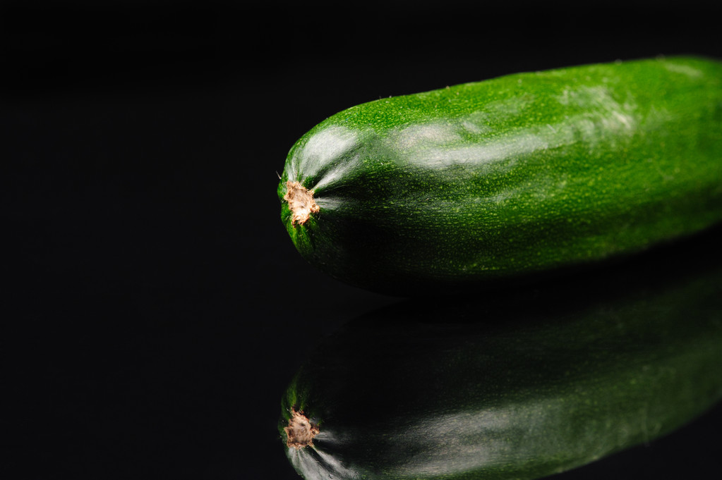 groene komkommer op de zwarte achtergrond  - Foto, afbeelding
