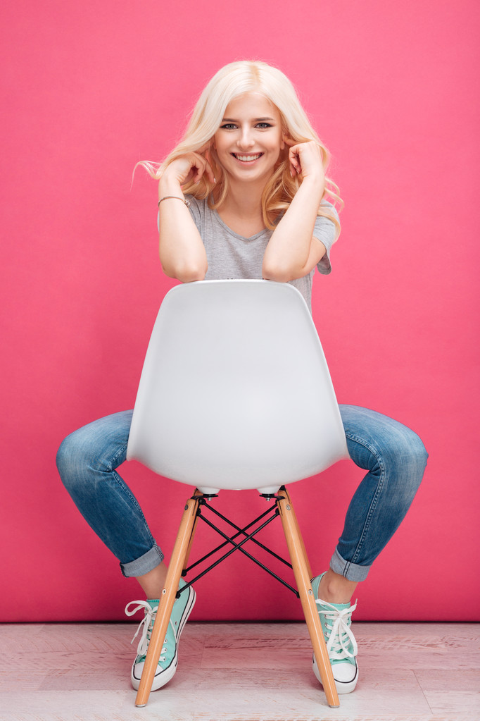 Ritratto di una bella donna sorridente seduta sulla sedia
  - Foto, immagini