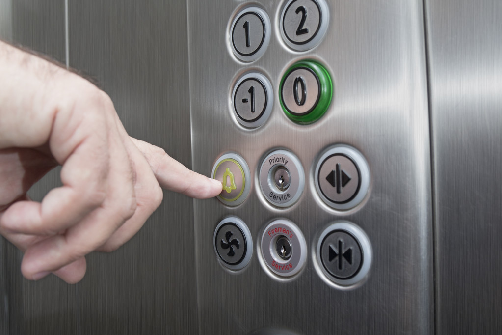 Dedo índice pulsando el botón de alarma en el ascensor
 - Foto, Imagen
