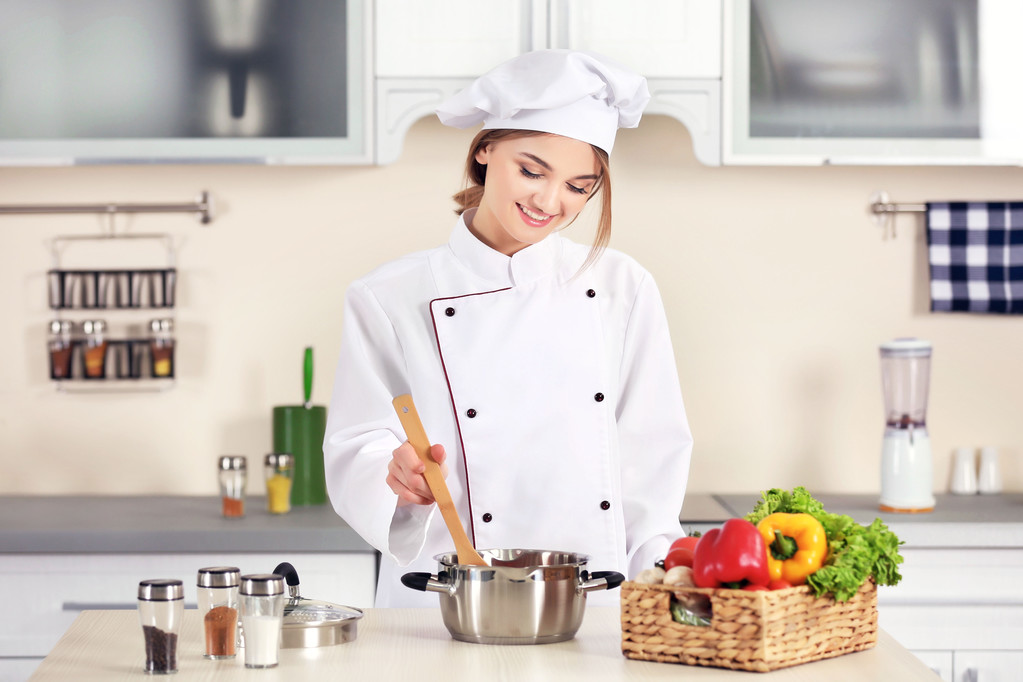 jonge vrouw koken in keuken - Foto, afbeelding
