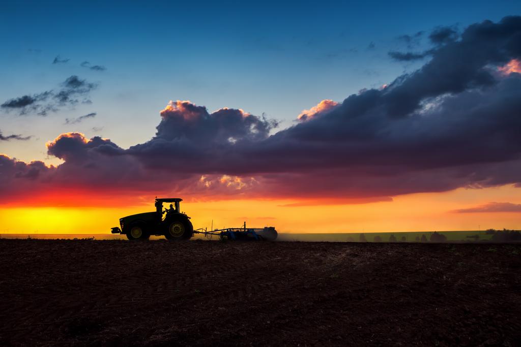 Landwirt mit Traktor bereitet Land mit Saatbettmulchgerät vor - Foto, Bild
