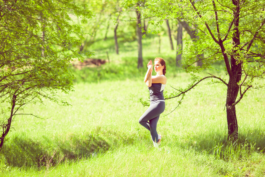 Молода дівчина робить йогу в парку
 - Фото, зображення
