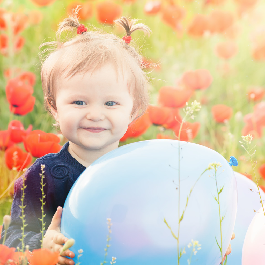 Αστεία παιδάκι που κρατάει ένα μπαλόνι εξωτερική στο πεδίο παπαρούνας - Φωτογραφία, εικόνα